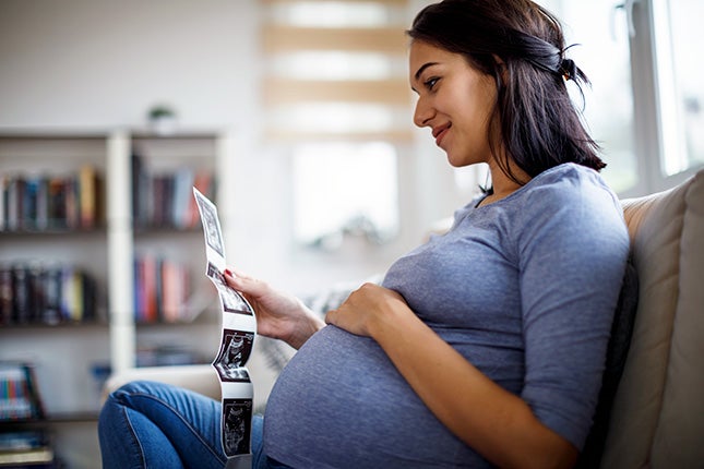 Pregnant mother looking at ultrasound photos